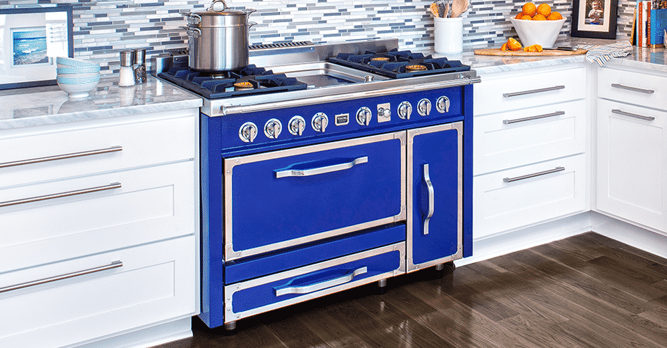 vibrant blue Viking range in a remodeled kitchen with dark wood floors, white cabinets, and grey countertops