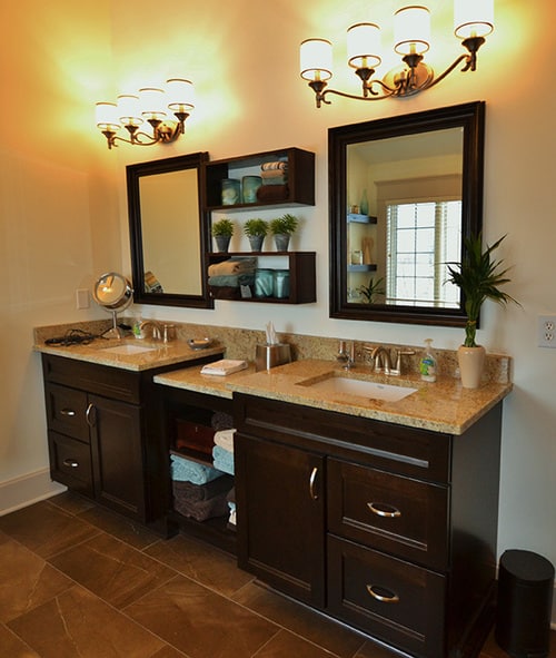 double sinks with storage shelves in between and 4-light fixtures above each vanity