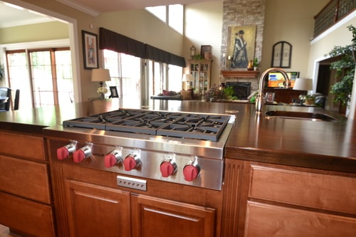 gas range with red knobs built in to wood cabinets